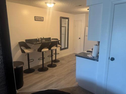a kitchen with a table and stools in a room at Elegance Escape 