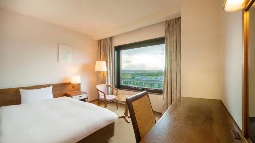 a hotel room with a bed and a large window at ANA Holiday Inn Iwate Kitakami by IHG in Kitakami
