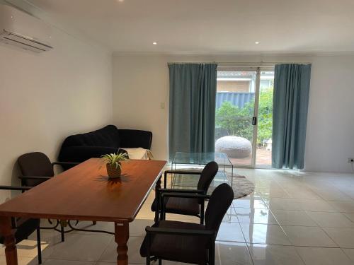 a living room with a wooden table and chairs at Close to shops & airport in Perth