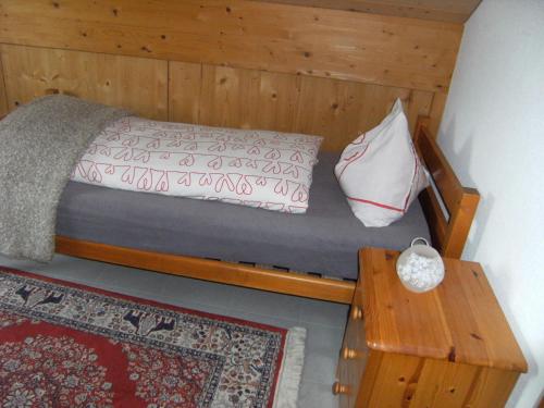 a small bedroom with a bed and a table at Appartement de vacances Niederer in La Côte-aux-Fées