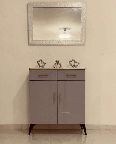 a bathroom cabinet with a mirror on the wall at Modern & comfortable house in Hainamosa