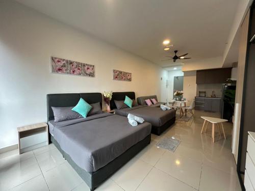 a bedroom with two beds and a living room at Alinea suites Luxury near by shah alam in Shah Alam