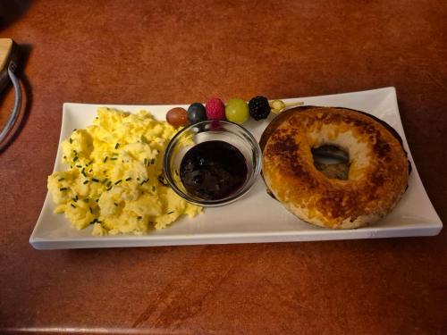 a plate of eggs and a bagel on a table at Refuge du Poète in Longueuil