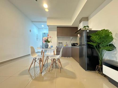 a kitchen with a table and chairs and a refrigerator at Alinea suites Luxury near by shah alam in Shah Alam