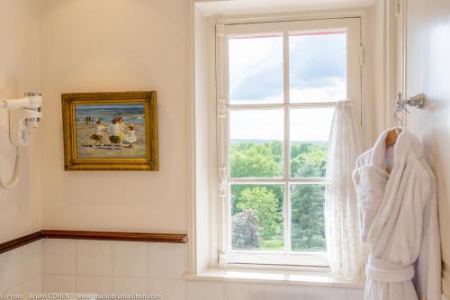 a bathroom with a window and a towel at Le Château de la Tour in Gouvieux