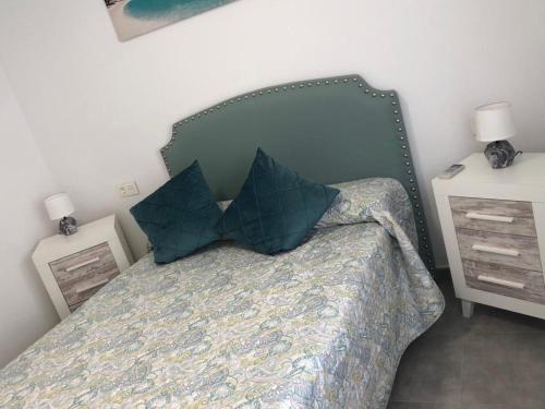a bedroom with a bed with pillows and two night stands at El Rincón de Agua Amarga lll in Níjar