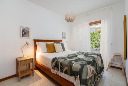 a bedroom with a bed and a window at 1 Bedroom apt with pool access in Albufeira