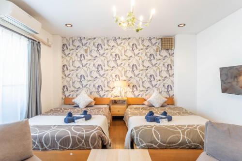 a room with two beds and a chandelier at kizahashi-south-Osaka 200m2 family 5bedroom tabletennis in Osaka