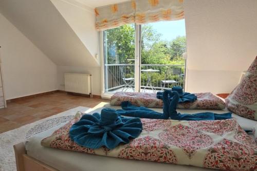 Un dormitorio con dos camas con lazos azules en ellas. en Haus Bremers Hafen, en Borkum
