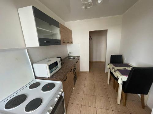 a kitchen with a stove and a microwave at Проста і затишна квартира! Бульвар Шевченко in Cherkasy