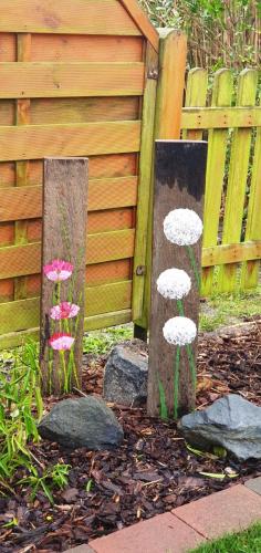 a garden with two wooden posts and some rocks at Sandburg in Borkum