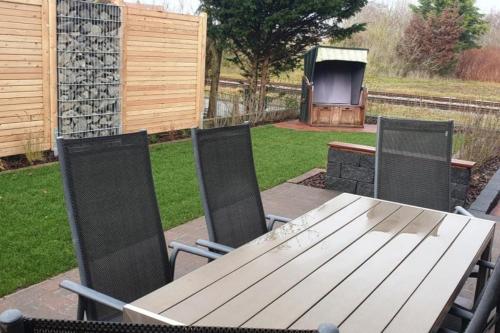 a wooden table and chairs with a television in a yard at Sandburg in Borkum
