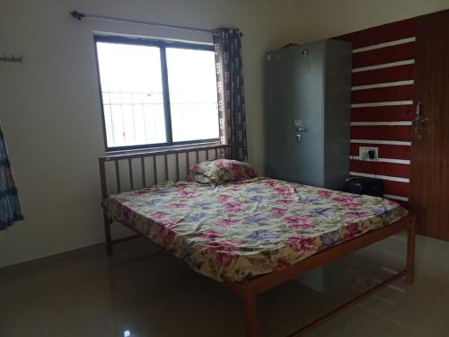 un petit lit dans une chambre avec une fenêtre dans l'établissement Potdar holiday home & risort, à Chandoli