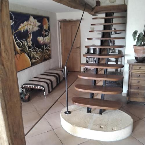 a spiral staircase in a room with a couch at chambres d'hôtes de la colline in Chenay-le-Châtel