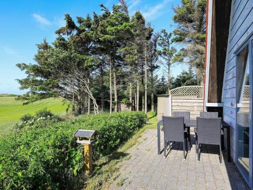 a patio with chairs and a table on a house at 7 person holiday home in Lemvig-By Traum in Trans