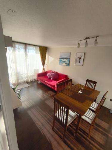 a living room with a red couch and a table at Hermosa Vista La serena in La Serena