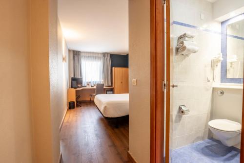 a small room with a bed and a bathroom at Travelodge Murcia in Murcia
