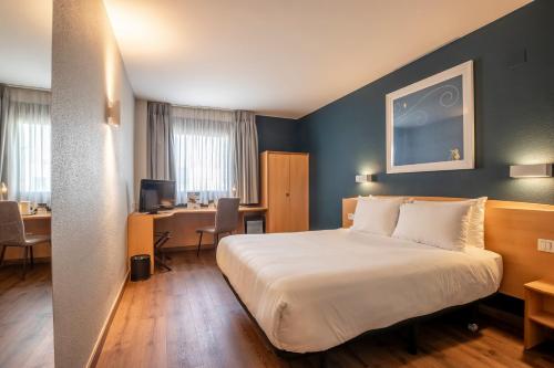 a hotel room with a bed and a desk at Travelodge Murcia in Murcia