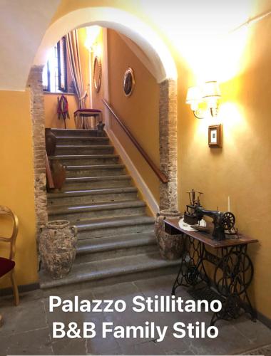 a hallway with a staircase in a house with a table at Bed and Breakfast Family Palazzo Stillitano Stilo in Stilo