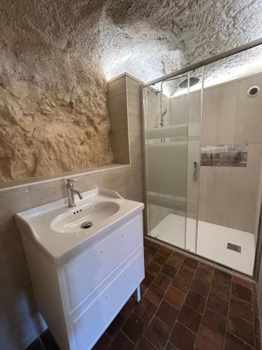 a bathroom with a sink and a shower at Habitat troglodyte typique et confortable in Villaines-les-Rochers