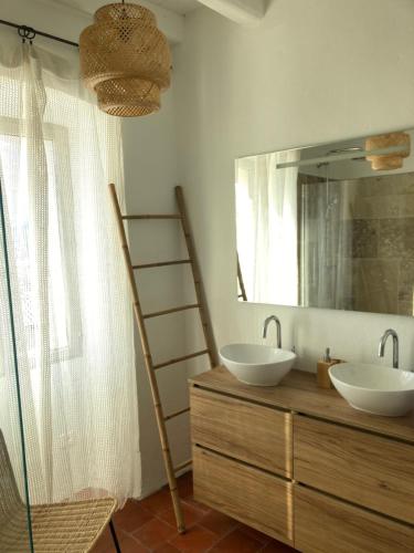 a bathroom with two sinks and a large mirror at L’Attellu in Feliceto
