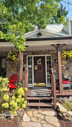 a front porch of a house with a red chair at Refuge du Poète in Longueuil