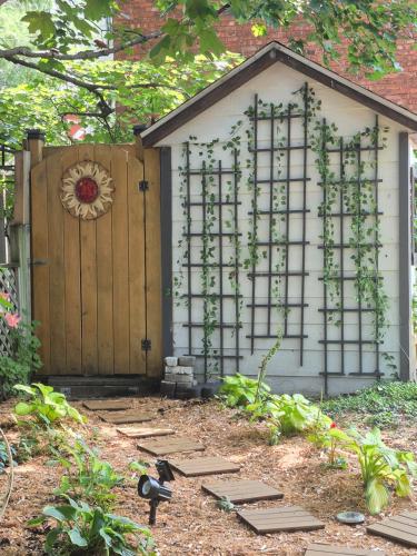 a wooden gate with ivy on it in a garden at Refuge du Poète in Longueuil