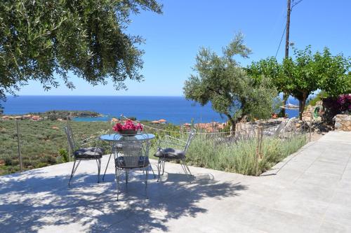 a table and chairs with a view of the ocean at Athina's Stone House in Kardamyli in Kardamili