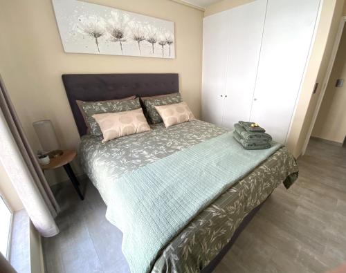 a bedroom with a bed with a green comforter at Luxury Holiday Apartment mit 2 Schlafzimmern am Strand von Hout Bay in Hout Bay
