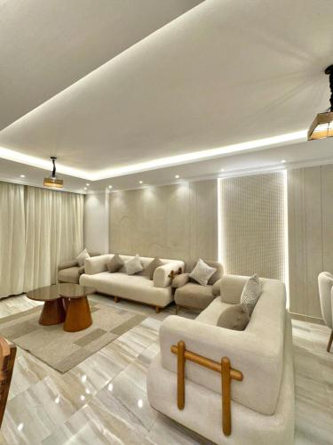 a living room with two couches and a table at Pyramids View Residence Apartment in Cairo