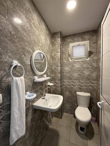 a bathroom with a toilet and a sink and a mirror at Dream View Luxe in Rafrāf