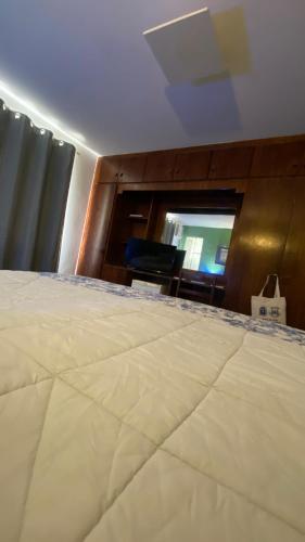 a bedroom with a large bed and a mirror at Mara Palace Hotel in Vassouras