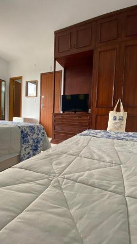 a bedroom with a large bed and a television at Mara Palace Hotel in Vassouras