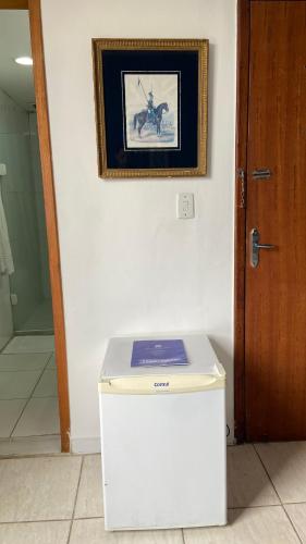 a white refrigerator in a room with a picture on the wall at Mara Palace Hotel in Vassouras
