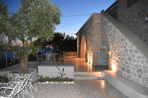 a brick wall with an outdoor patio with a table at Athina's Stone House in Kardamyli in Kardamili