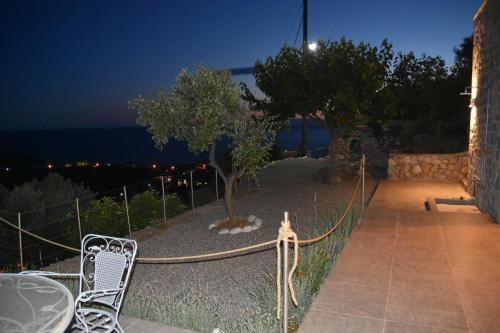 a patio with a table and a tree at night at Athina's Stone House in Kardamyli in Kardamili