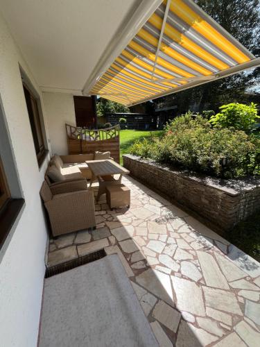 a patio with a table and chairs on a patio at Appartementhaus FICHTERN in Sankt Johann in Tirol