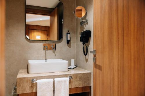 a bathroom with a sink and a mirror and towels at NearYo Hotels in Marrakech