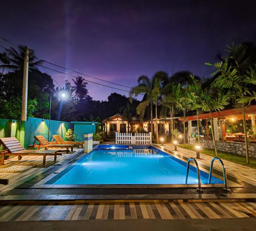 ein Schwimmbad in einem Haus in der Nacht in der Unterkunft Max Safari Villa in Udawalawe