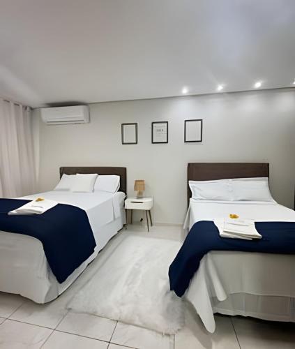 a bedroom with two beds and a table in it at Loft Estilo seguro e bem localizado in Rio Branco