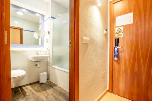 a bathroom with a toilet and a sink at Travelodge Murcia in Murcia