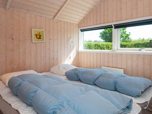 a large bed with blue pillows in a room at 4 star holiday home in Hemmet in Hemmet