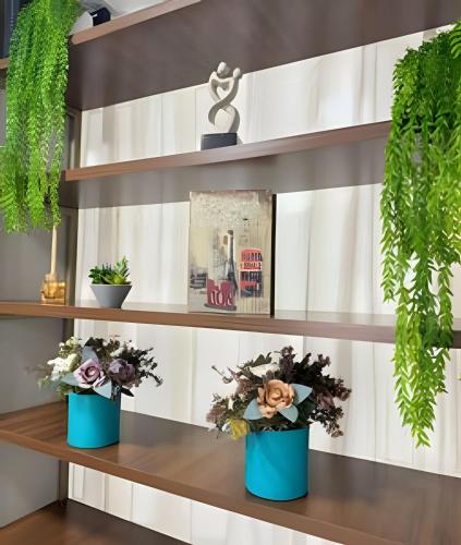 a shelf with two blue vases with flowers at Loft Estilo seguro e bem localizado in Rio Branco