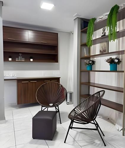 two chairs and a table in a room at Loft Estilo seguro e bem localizado in Rio Branco