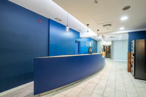 an office lobby with blue walls and a reception counter at Travelodge Murcia in Murcia