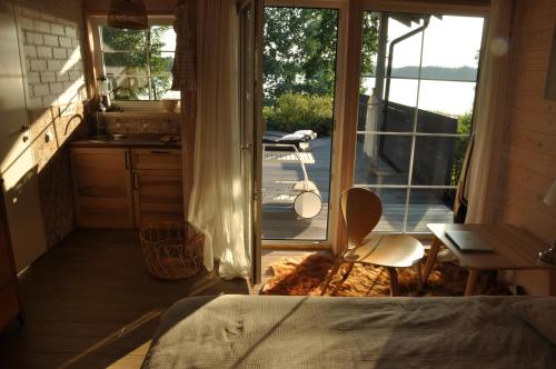 a bedroom with a bed and a view of a balcony at Mokaito Namai in Sadžiūnai