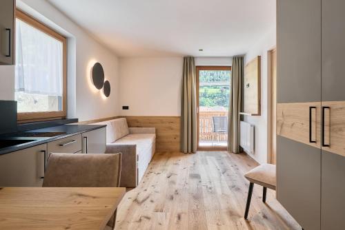 a kitchen and living room with a couch and a table at Hotel Schmuckhof in Chiusa