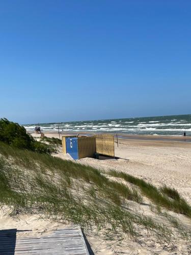 a beach with a building on the sand and the ocean at EVA Studio in Palanga