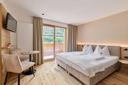 a hotel room with a large bed and a window at Hotel Schmuckhof in Chiusa