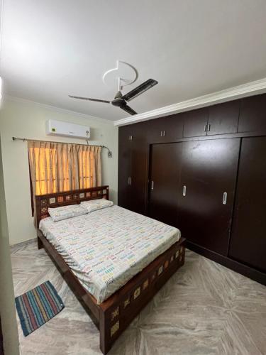 Un dormitorio con una cama y un ventilador de techo. en Happy living, en Gunadala